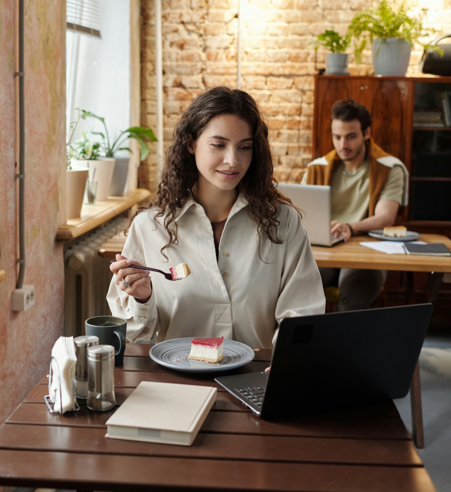 a woman is eating a cake and working at coffee shop