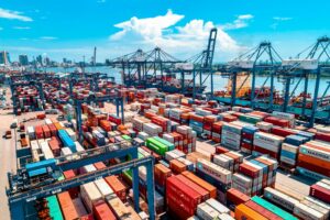 Stacked multi-coloured shipping containers organised in rows at a shipping port, used as a metaphor for the layered dependencies of a modern software supply chain