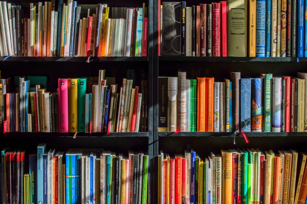 Rows of books on dark shelving.